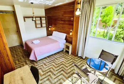 a hotel room with a bed and a tv at Colina Haus, casa vacacional Oxa in Oxapampa
