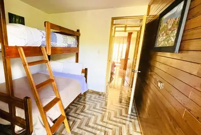a room with two bunk beds and a open door at Colina Haus, casa vacacional Oxa in Oxapampa