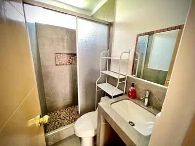 a bathroom with a shower and a sink and a toilet at Colina Haus, casa vacacional Oxa in Oxapampa
